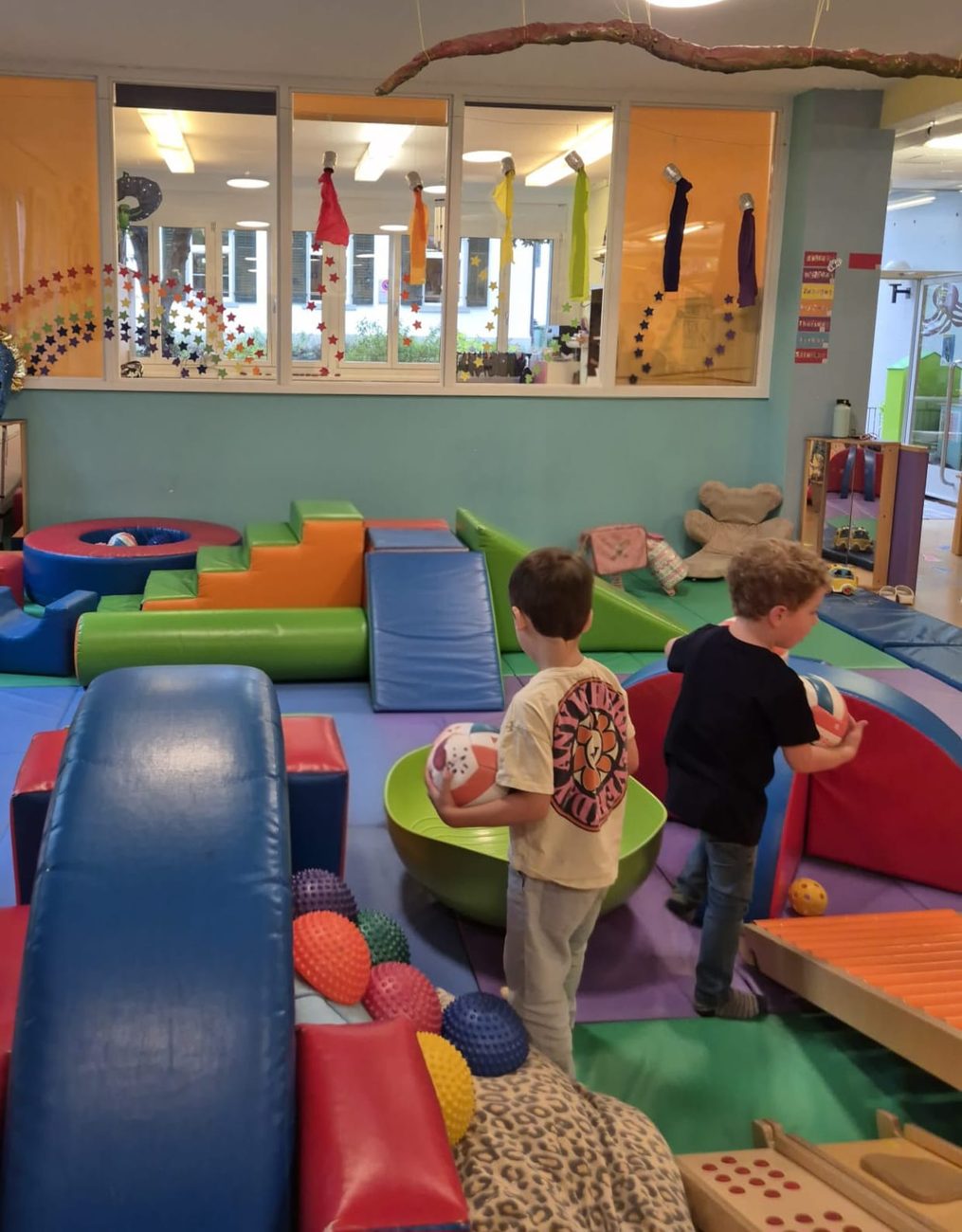 Two children from behind exploring a soft play room